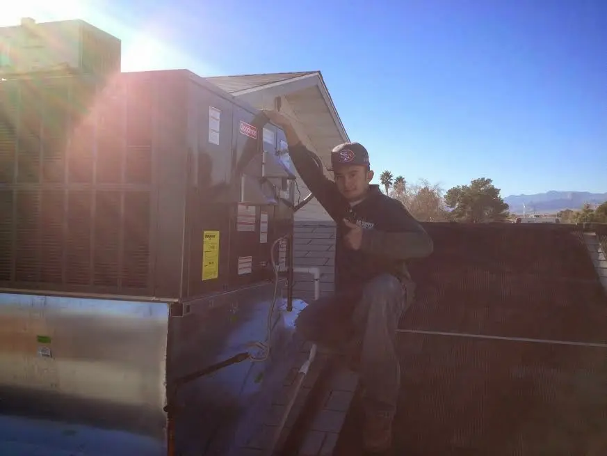 HVAC technician performing Air Duct Cleaning on a rooftop unit in Middlesex